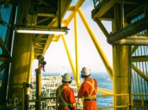 Offshore rig with two workers wearing safety gear